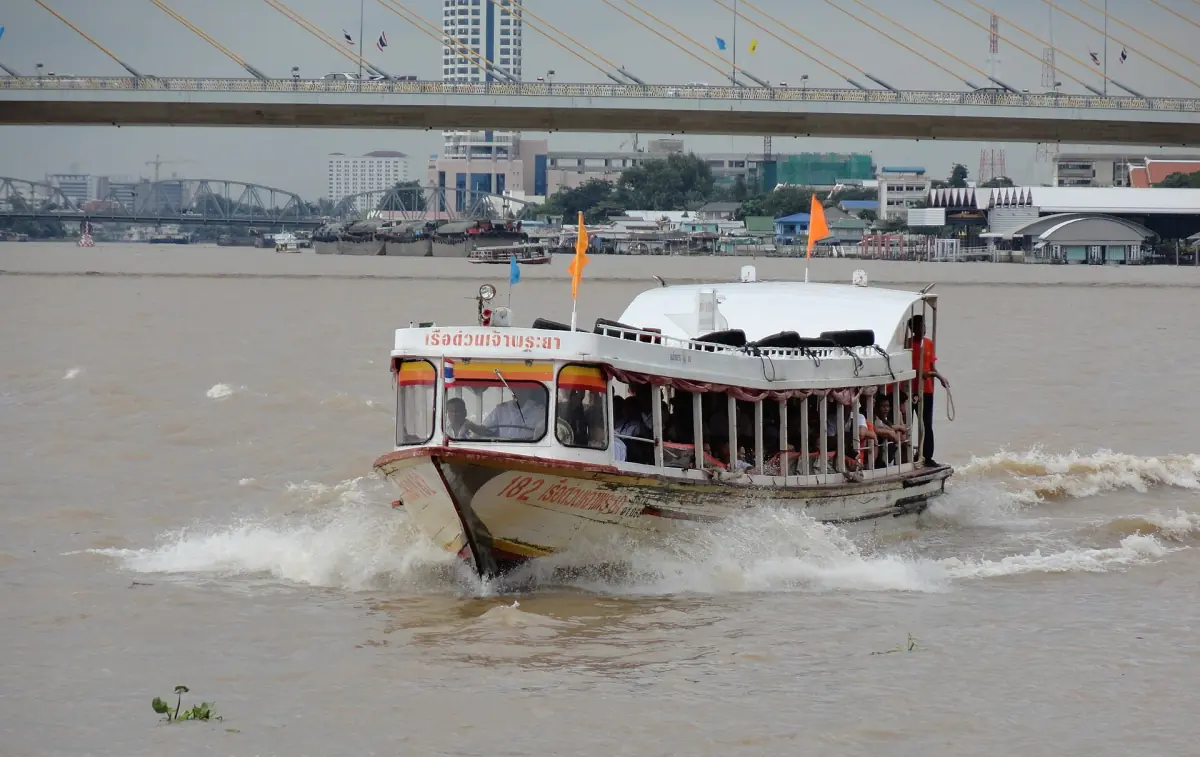 A Chao Phraya Express Boat with an orange flag
